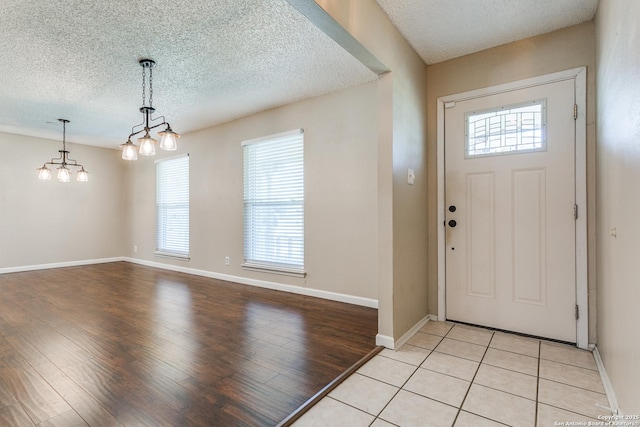 5918 Oak Country Way, San Antonio, TX 78247 - foyer with an inviting chandelier, baseboards, light wood-style floors, and a textured ceiling