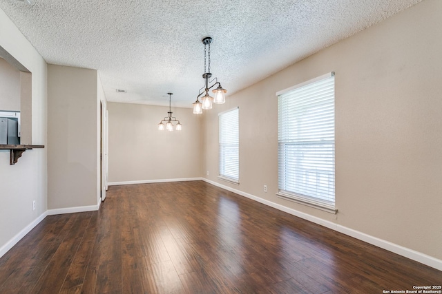 5918 Oak Country Way, San Antonio, TX 78247 - unfurnished dining area featuring dark wood-style flooring, a textured ceiling, visible vents, baseboards, and a notable chandelier