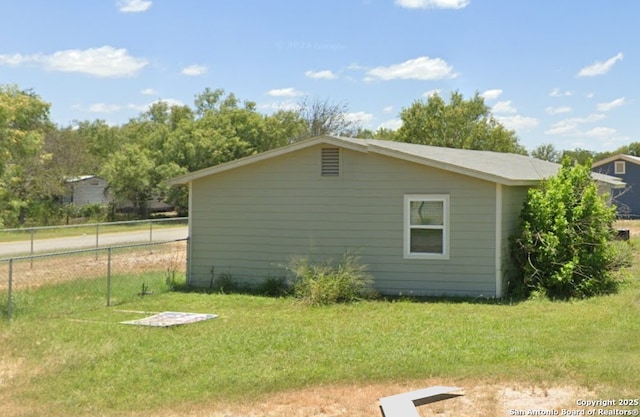 view of side of property with a yard and fence