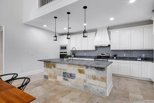 kitchen featuring a sink, backsplash, appliances with stainless steel finishes, and premium range hood