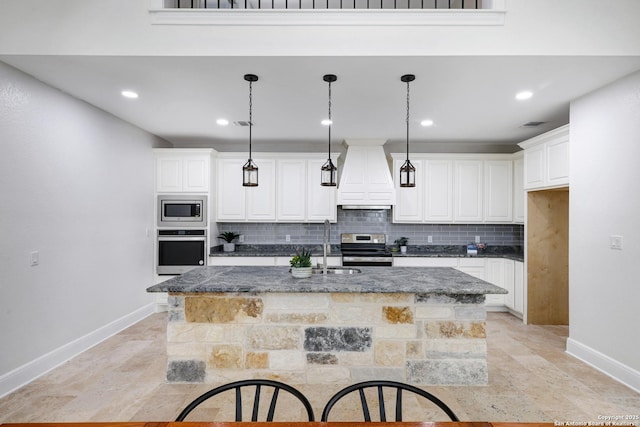 kitchen featuring backsplash, appliances with stainless steel finishes, white cabinetry, and custom range hood