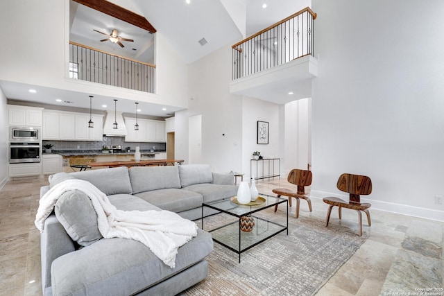 living area with visible vents, a ceiling fan, recessed lighting, a high ceiling, and baseboards