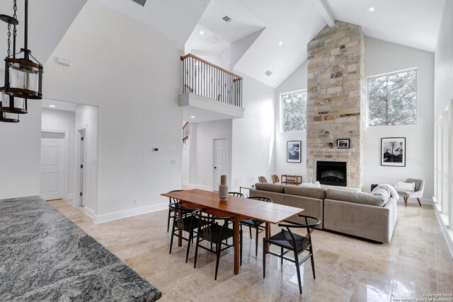 dining area with a wealth of natural light, stairway, beamed ceiling, and a fireplace