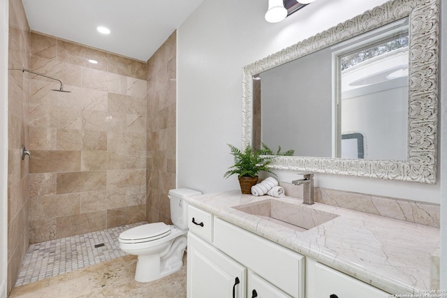 full bathroom with recessed lighting, tiled shower, toilet, and vanity