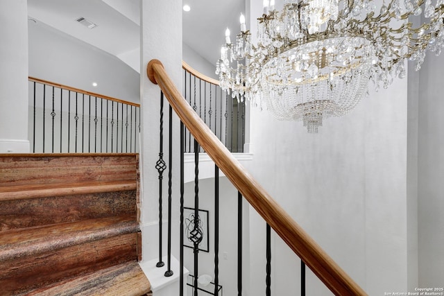 stairs with visible vents and an inviting chandelier