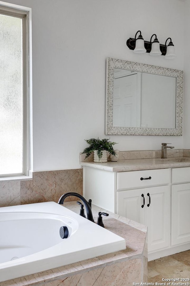 bathroom with vanity and a garden tub