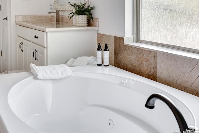 full bathroom featuring vanity and a washtub