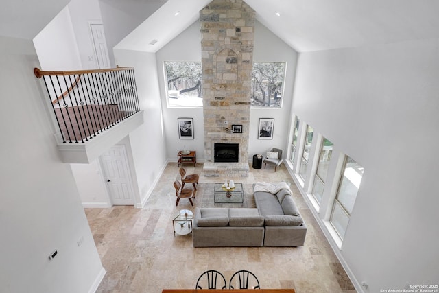 living area featuring visible vents, a fireplace, baseboards, and high vaulted ceiling