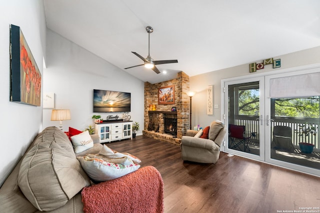 living area featuring ceiling fan, lofted ceiling, a brick fireplace, and wood finished floors