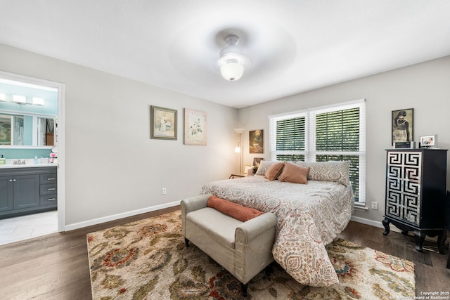 bedroom with a sink, baseboards, and wood finished floors