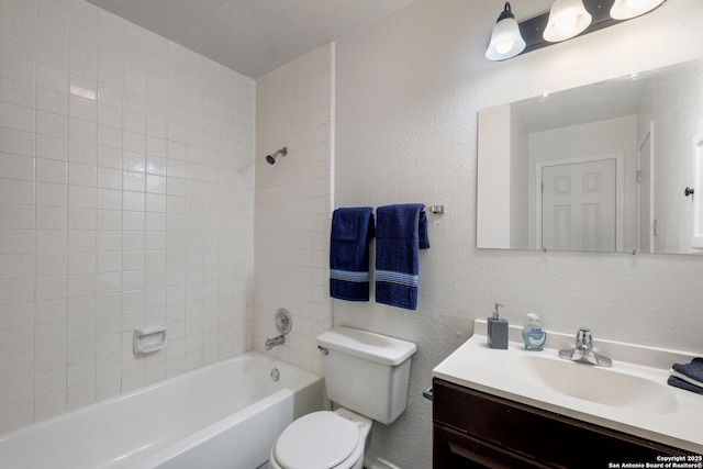 full bathroom featuring shower / bathing tub combination, toilet, vanity, and a textured wall