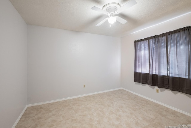 unfurnished room featuring a ceiling fan, baseboards, and a textured ceiling