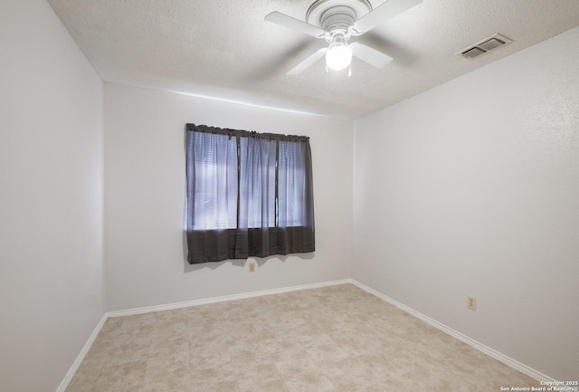 empty room with baseboards, visible vents, a textured ceiling, and a ceiling fan