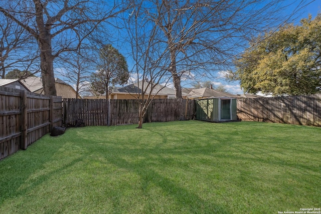 view of yard with an outdoor structure, a storage unit, and a fenced backyard