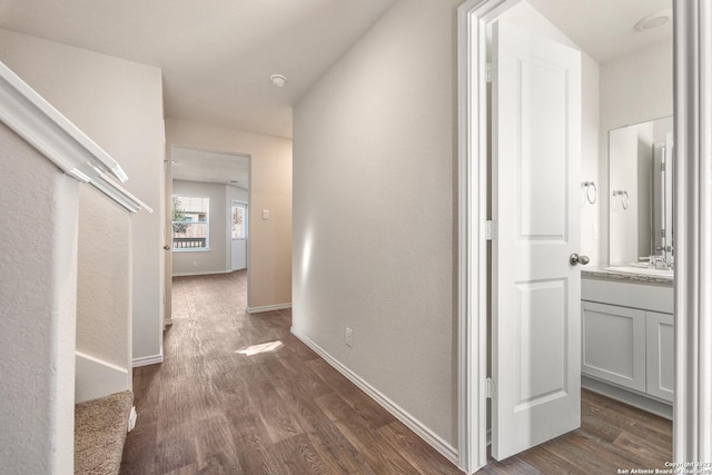 hall with dark wood-style floors and baseboards