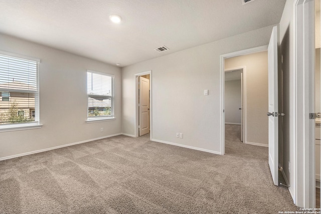 unfurnished bedroom featuring visible vents, carpet flooring, and baseboards