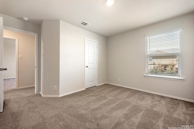 unfurnished bedroom with carpet flooring, baseboards, and visible vents