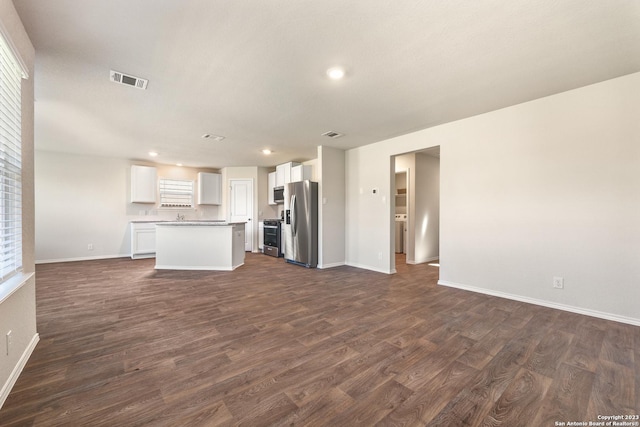 unfurnished living room with dark wood-type flooring, recessed lighting, baseboards, and visible vents