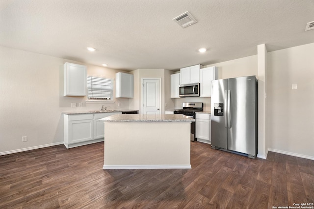 kitchen featuring dark wood finished floors, visible vents, stainless steel appliances, and a sink