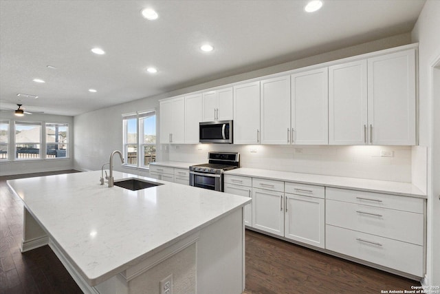 kitchen featuring a sink, stainless steel appliances, tasteful backsplash, and white cabinetry