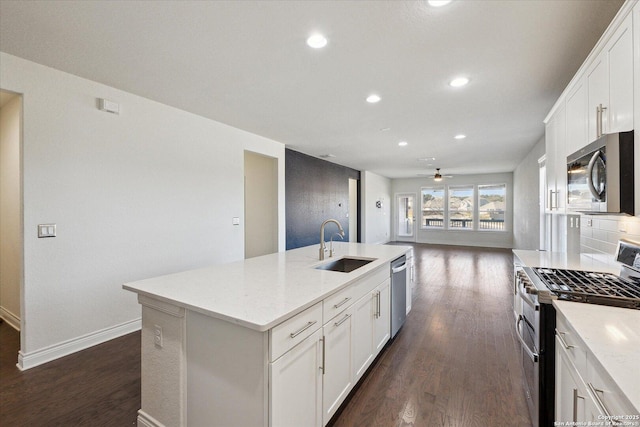 kitchen with a sink, stainless steel appliances, dark wood-type flooring, and a kitchen island with sink