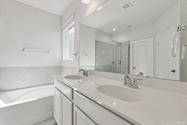 full bathroom with a shower stall, double vanity, visible vents, and a sink