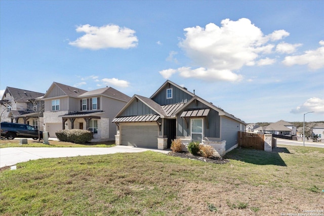 view of front of home with a front yard, driveway, a standing seam roof, a garage, and board and batten siding