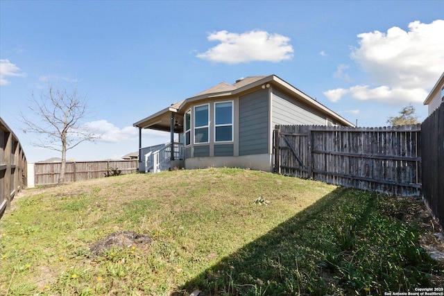 back of property featuring a fenced backyard and a yard