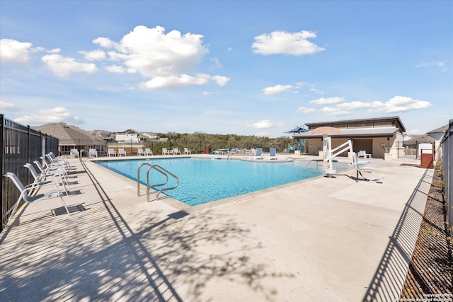 pool with a patio and fence