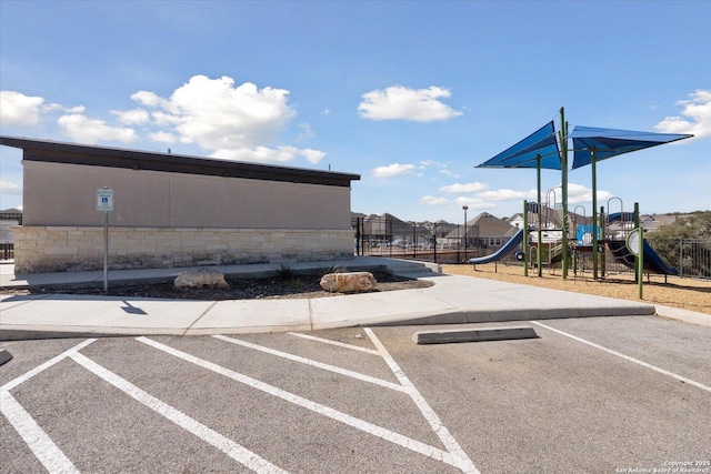 uncovered parking lot featuring fence and playground community