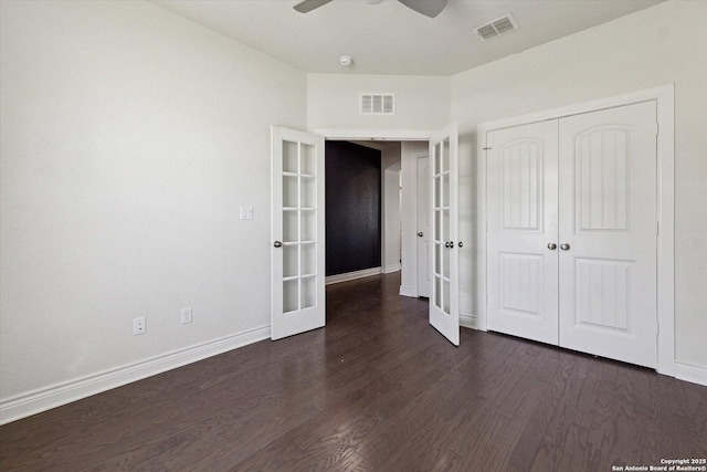 unfurnished bedroom with dark wood finished floors, french doors, visible vents, and baseboards