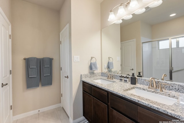 full bathroom featuring tile patterned flooring, a stall shower, double vanity, and a sink