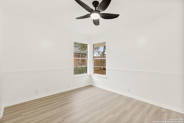 empty room with baseboards, wood finished floors, and a ceiling fan