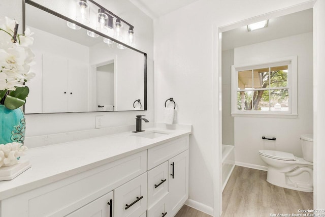 full bath featuring vanity, toilet, wood finished floors, and baseboards