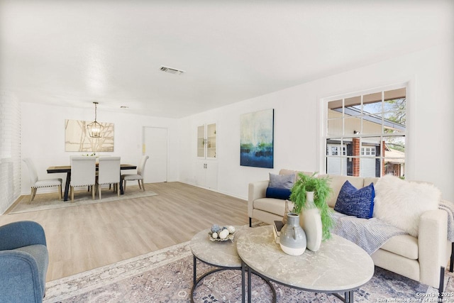 living area with visible vents, baseboards, and wood finished floors