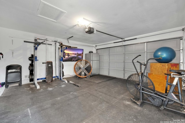 garage with a garage door opener and freestanding refrigerator