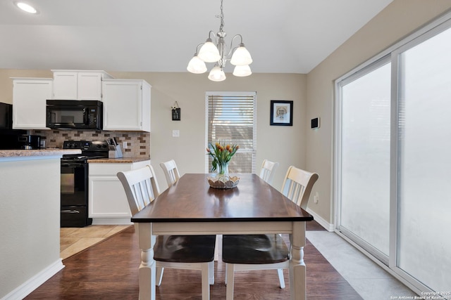 dining room with baseboards and an inviting chandelier