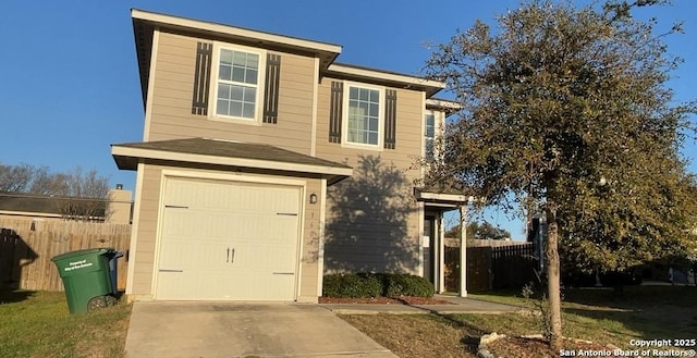 traditional-style house featuring driveway, an attached garage, and fence