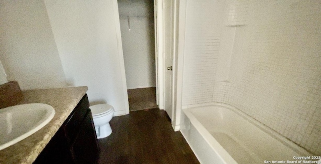 bathroom featuring toilet, vanity, and  shower combination