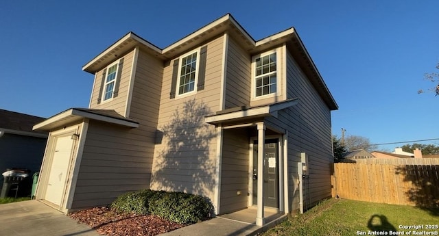 view of front of property featuring a garage and fence