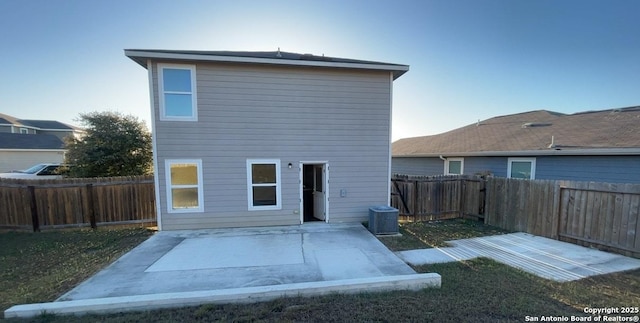 rear view of house featuring a patio, cooling unit, and a fenced backyard