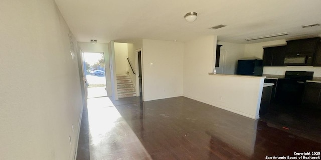 kitchen with visible vents, black microwave, light countertops, baseboards, and dark cabinets