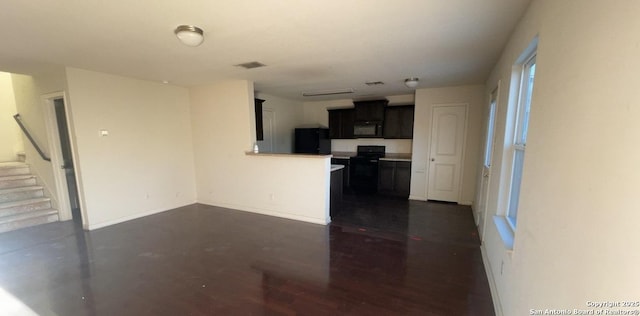 kitchen with visible vents, light countertops, a peninsula, dark cabinetry, and black appliances