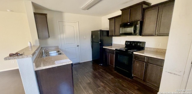 kitchen featuring black appliances, a sink, a peninsula, light countertops, and dark brown cabinets