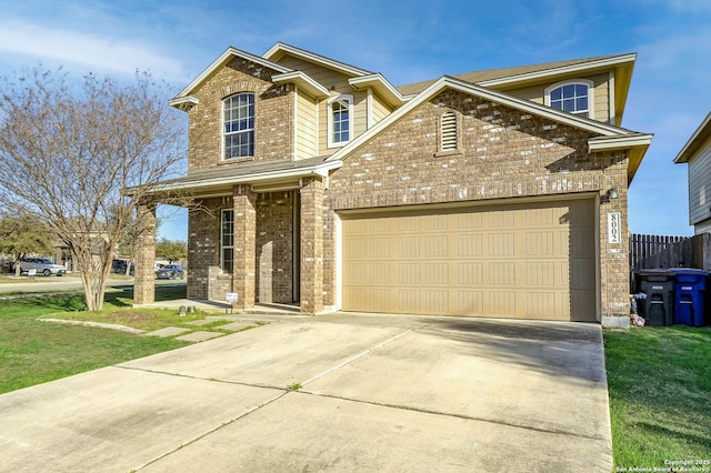 traditional-style home with driveway, brick siding, an attached garage, and a front yard