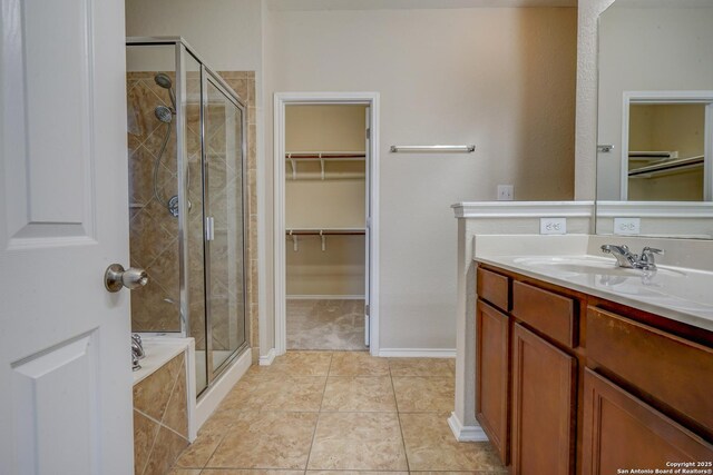 bathroom with vanity, a bathing tub, a stall shower, a spacious closet, and tile patterned floors