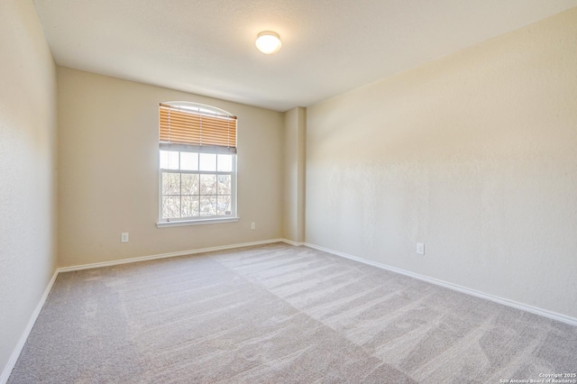 unfurnished room featuring carpet flooring and baseboards