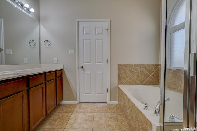 bathroom with a garden tub, vanity, and tile patterned flooring