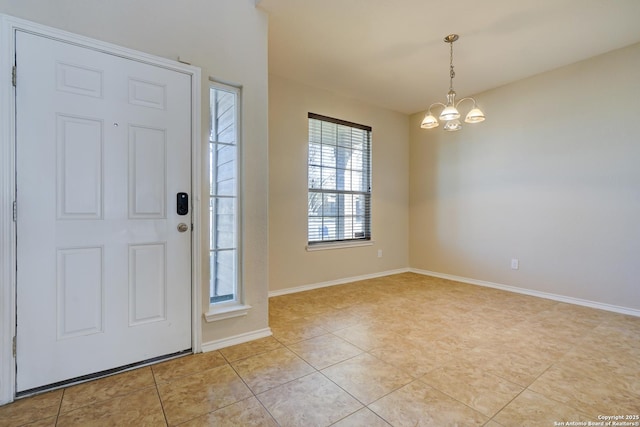 foyer featuring light tile patterned flooring, baseboards, and an inviting chandelier