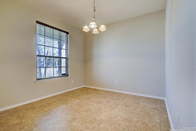 unfurnished room with a chandelier and baseboards